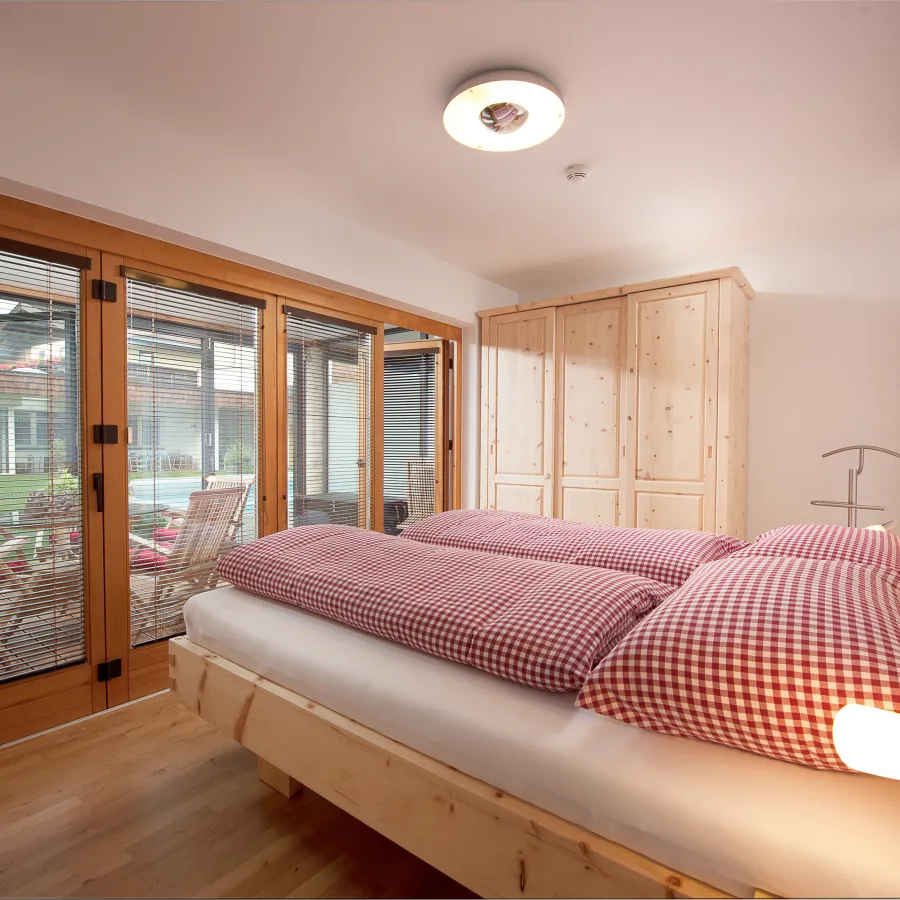 Schlafzimmer mit Doppelbett aus Zirbenholz im Apartment mit 3 Schlafzimmern