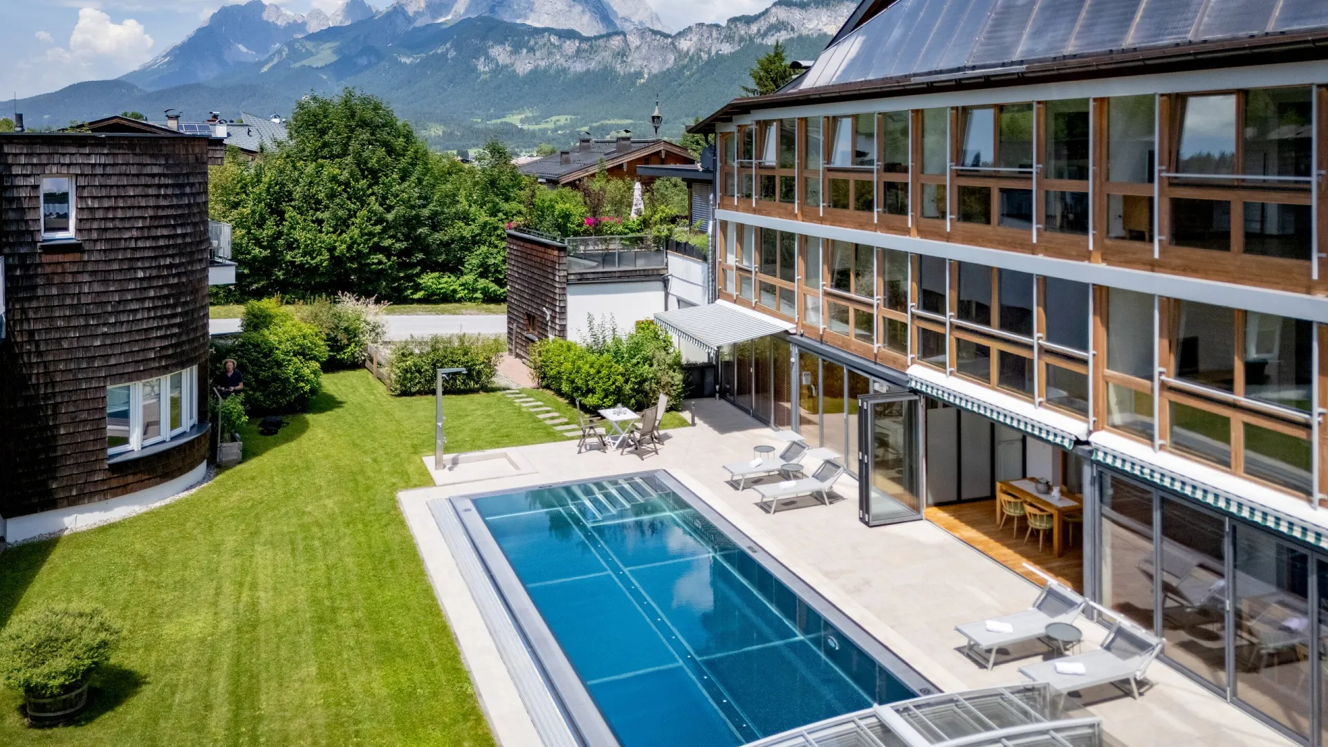 Poolbereich des Martinshofs von oben, im Hintergrund der Wilde Kaiser