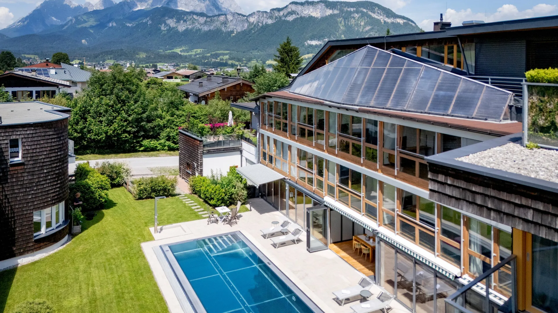 Apartmenthaus Martinshof mit Pool und Liegewiese vor dem Wilden Kaiser