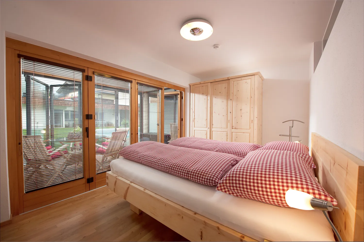 Schlafzimmer mit Doppelbett aus Zirbenholz im Apartment mit 3 Schlafzimmern
