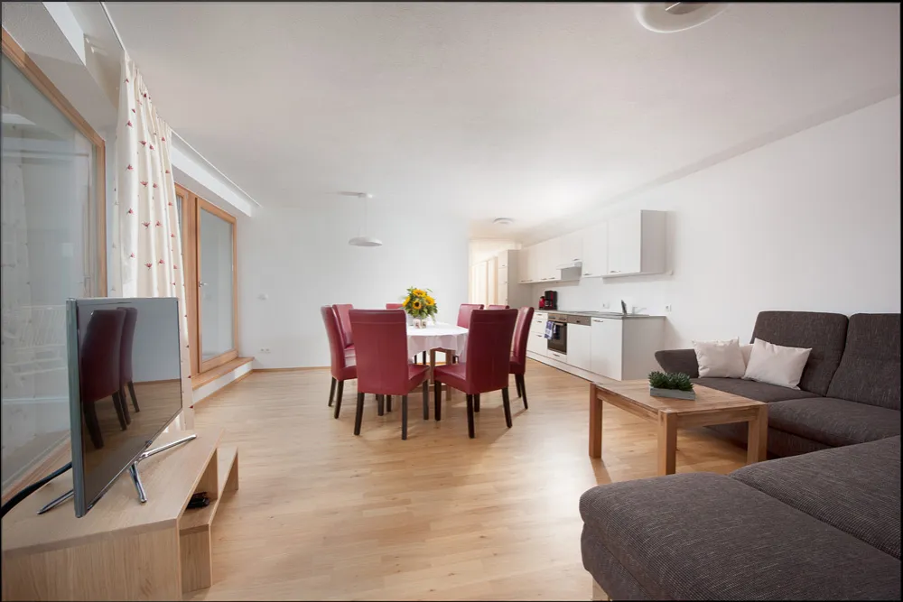 Wohnküche mit Esstisch und großem Ecksofa im Apartment mit 3 Schlafzimmern