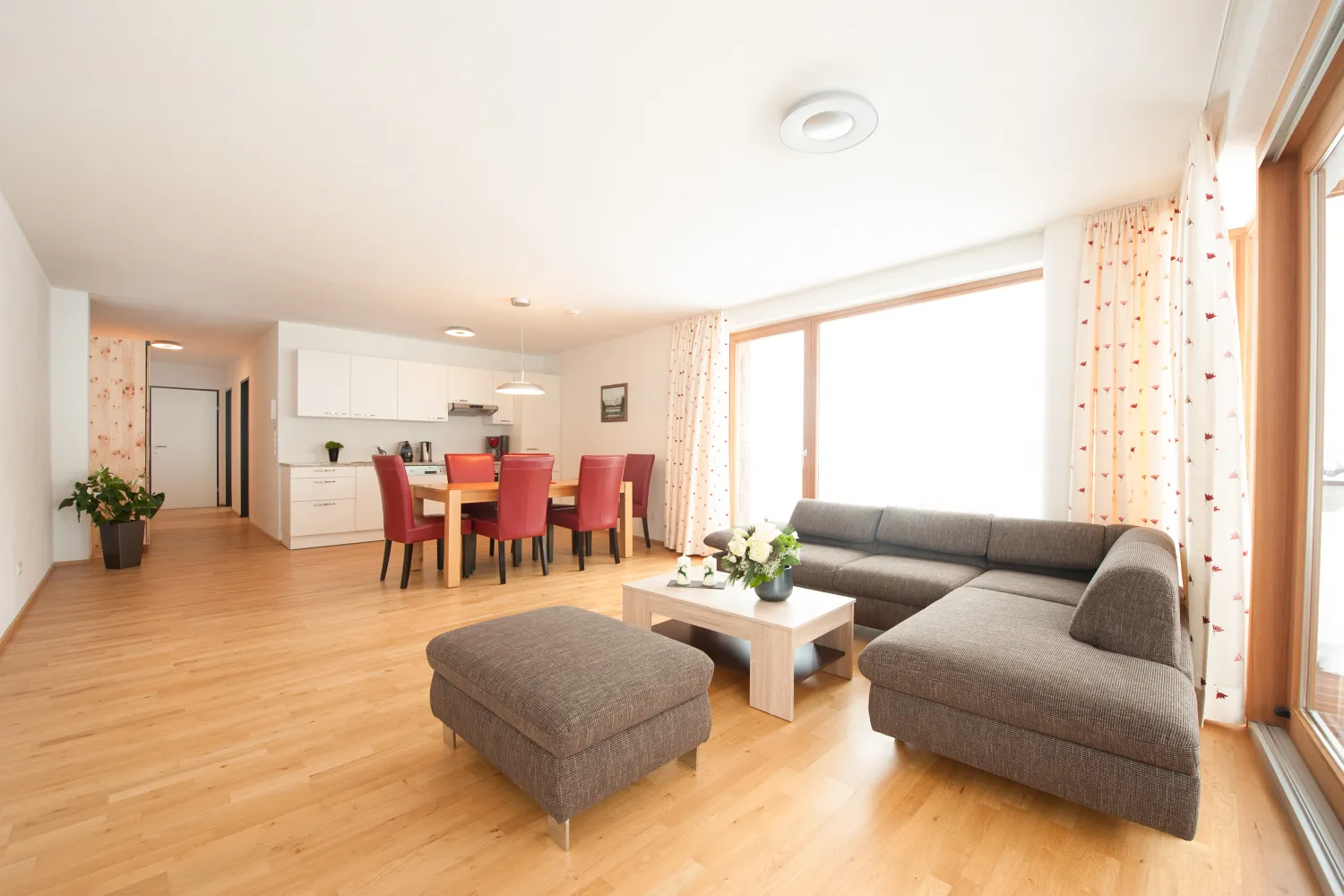 Wohnküche mit Esstisch und Ecksofa im Apartment mit 2 Schlafzimmern und Garten