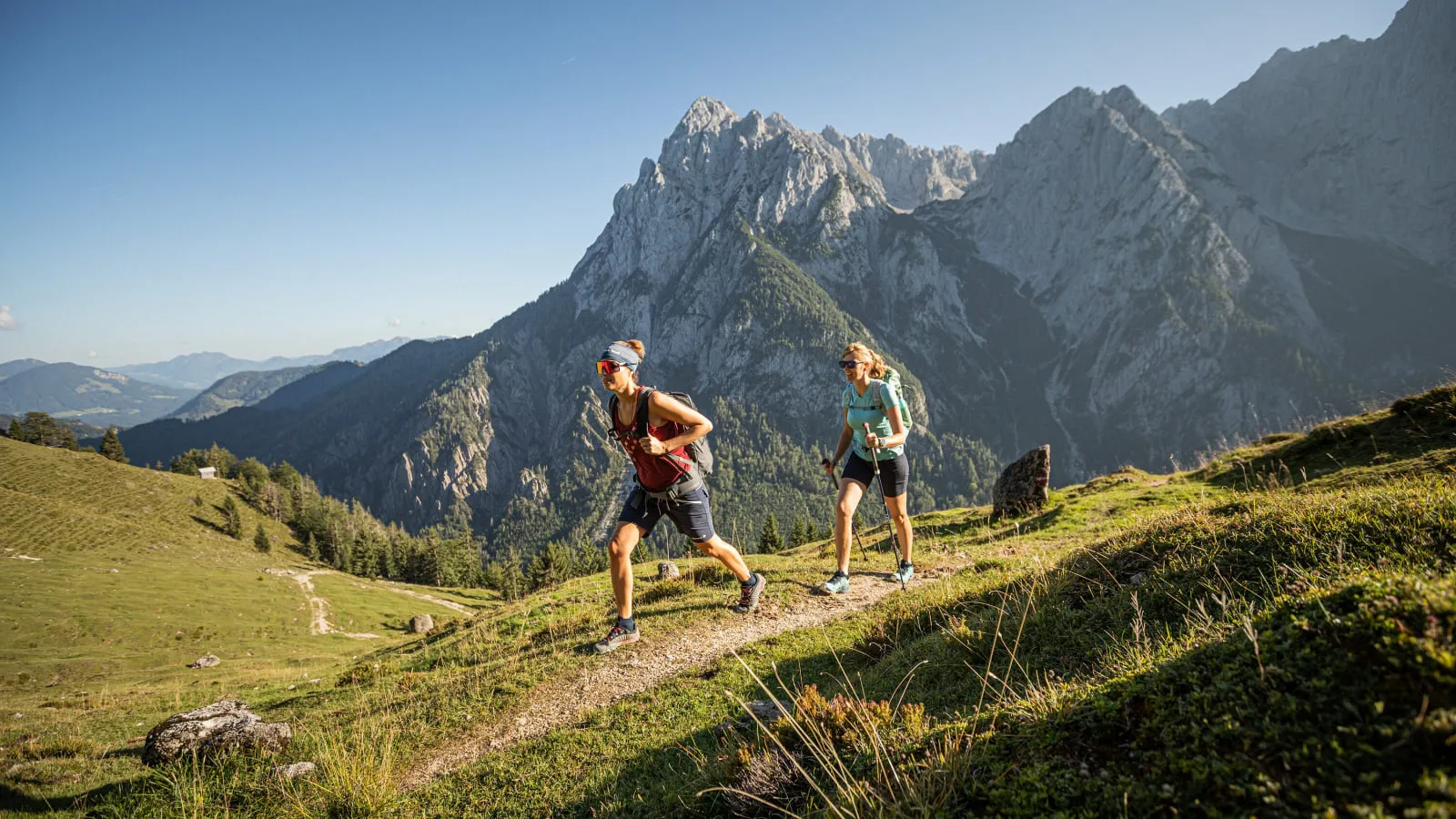 Zwei Wanderer auf einem Bergpfad vor schroffen Kalkgipfeln
