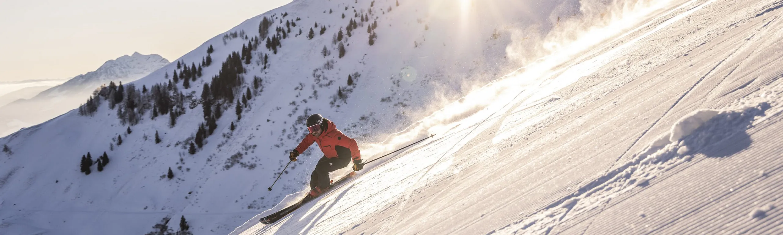 Skifahrer auf frisch präparierter Piste im Gegenlicht